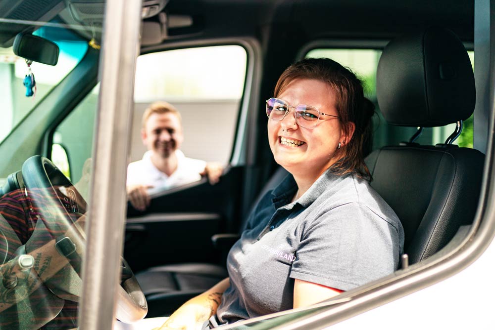 Lächelnde Fahrerin der City Ambulanz im Cockpit